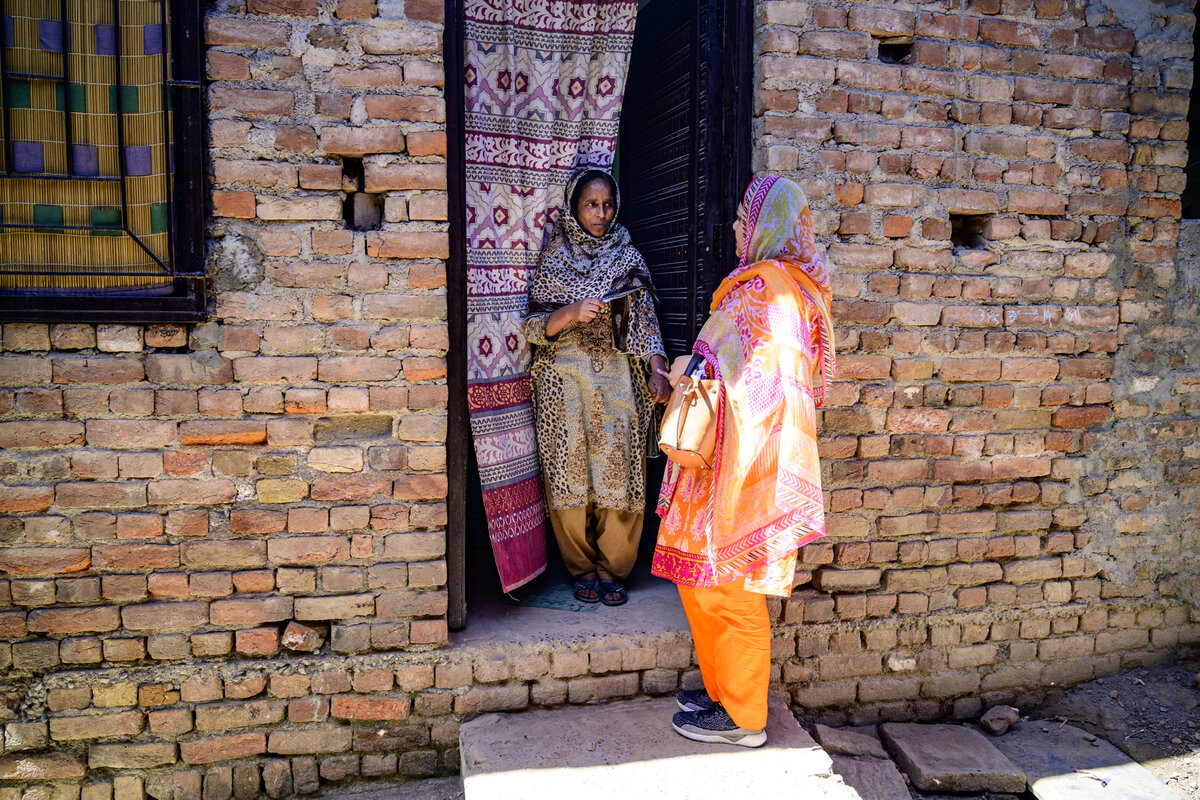 Islamabad, Pakistan - 5 May, 2019: Health worker speaking with the mother of a man with disabilities in the entrance of the family house during a field assistive technology survey for persons with disabilities in the outskirts of Islamabad. Photo: © WHO / NOOR / Sebastian Liste <br>