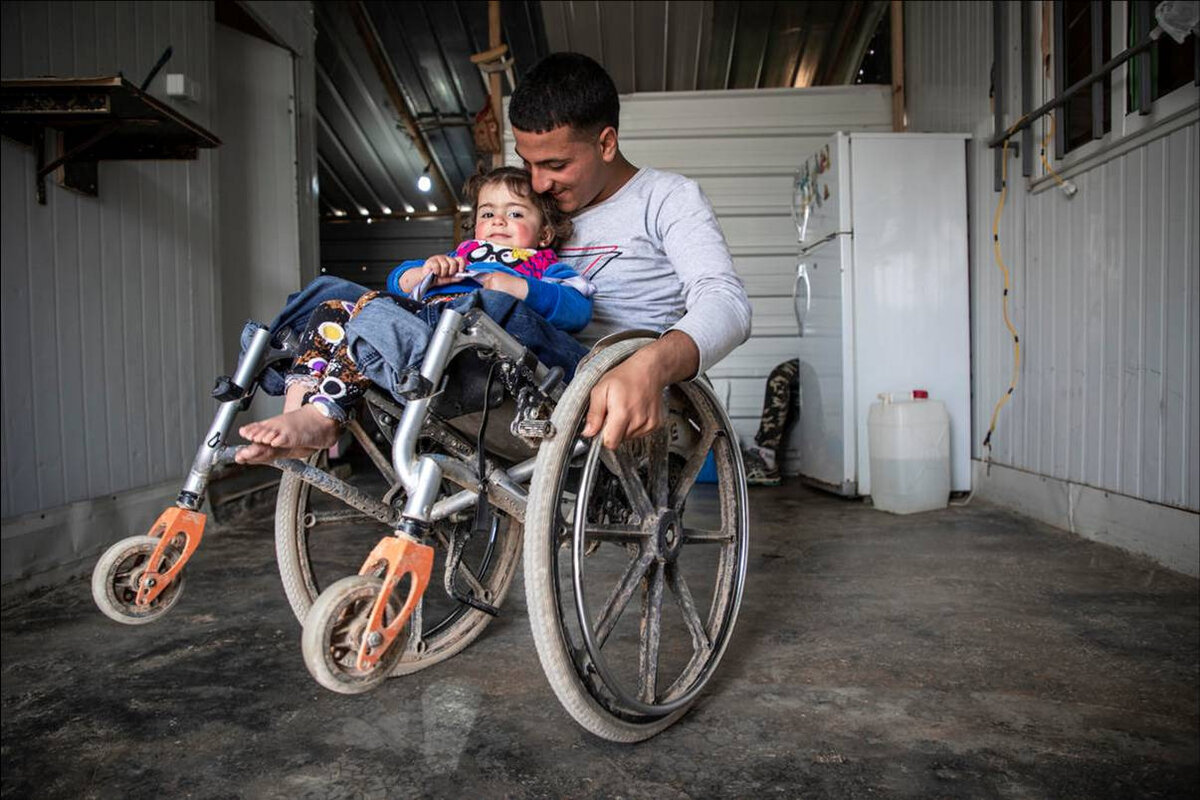 Ryian, 15, plays with his younger sister Siba, two, at their home in Za’atari camp for Syrian refugees, Jordan. Photo: © Jonathan Hyams / Save the Children