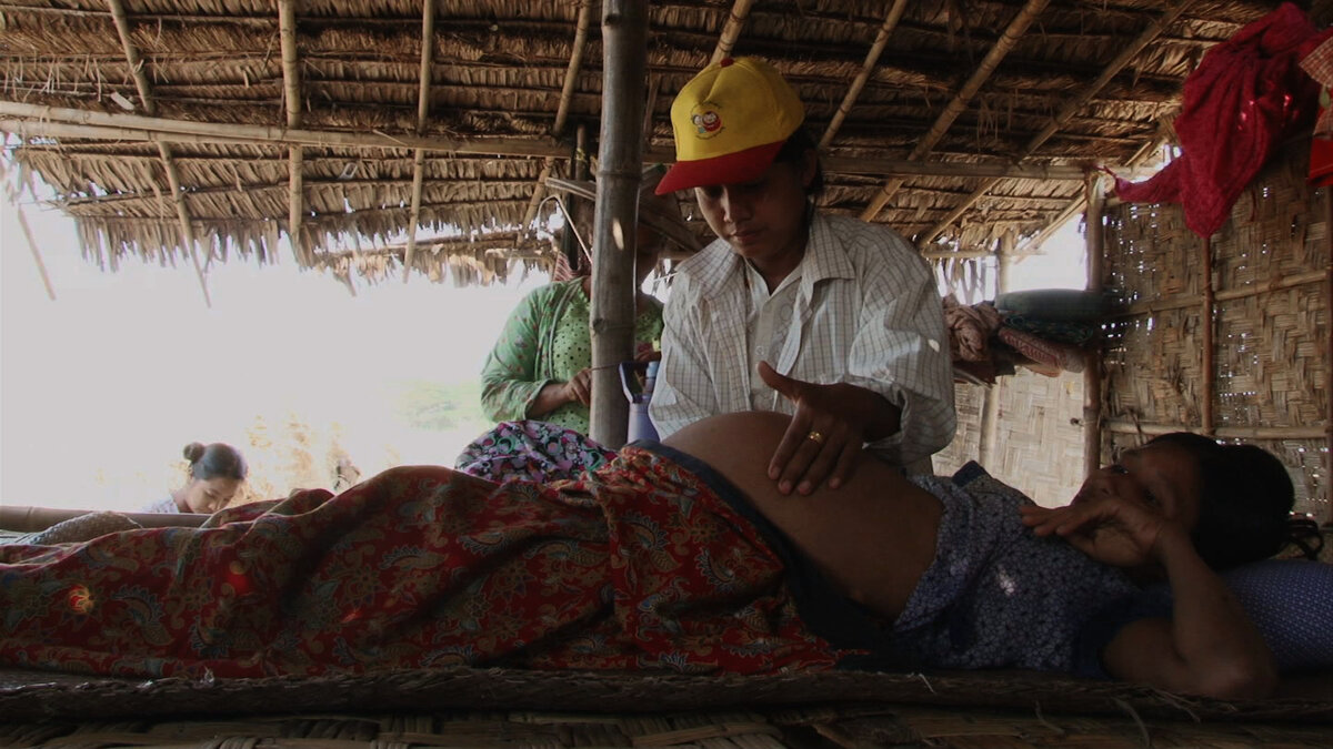 Myanmar Midwife Daw Nweni Cho visiting a pregnant lady in the Yangon River delta (2013). Photo: © Carine Weiss